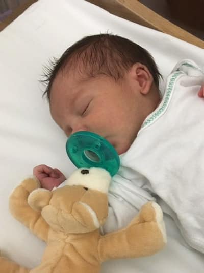 Premature baby sucking on a WubbaNub pacifier